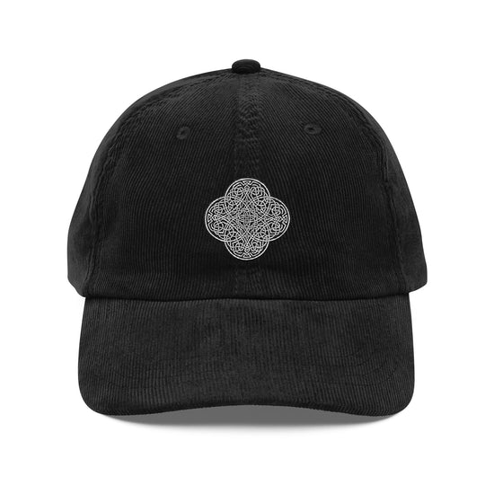 The front side of a black Xigfireon vintage corduroy cap embroidered with the Black & White Solid iteration of the `Reach Of The Spirit` Celtic knot design.