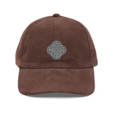 The front side of a brown Xigfireon vintage corduroy cap embroidered with the Black & White Solid iteration of the `Reach Of The Spirit` Celtic knot design.