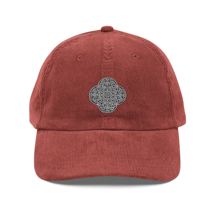 The front side of a burgundy Xigfireon vintage corduroy cap embroidered with the Black & White solid iteration of the `Reach Of The Spirit` Celtic knot design.