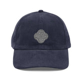 The front side of a navy blue Xigfireon vintage corduroy cap embroidered with the Black & White Solid iteration of the `Reach Of The Spirit` Celtic knot design.