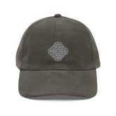 The front side of an olive green Xigfireon vintage corduroy cap embroidered with the Black & White Solid iteration of the `Reach Of The Spirit` Celtic knot design.