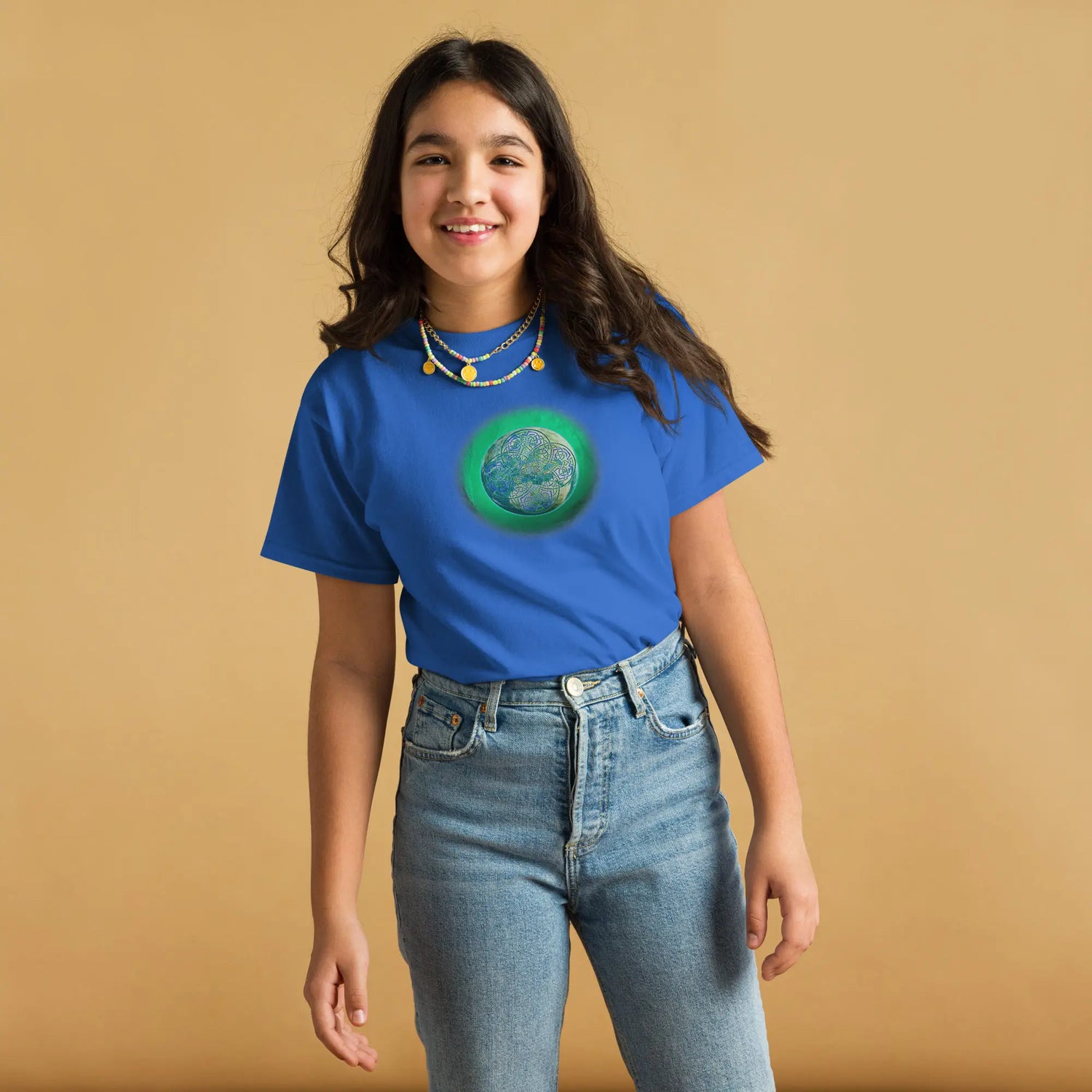 A young girl wearing a royal blue Xigfireon kids graphic t-shirt featuring the Deep Forest iteration of the `Reach Of The Spirit` Celtic knot design. The `Reach Of The Spirit` Celtic knot symbolizes Mother Earth.