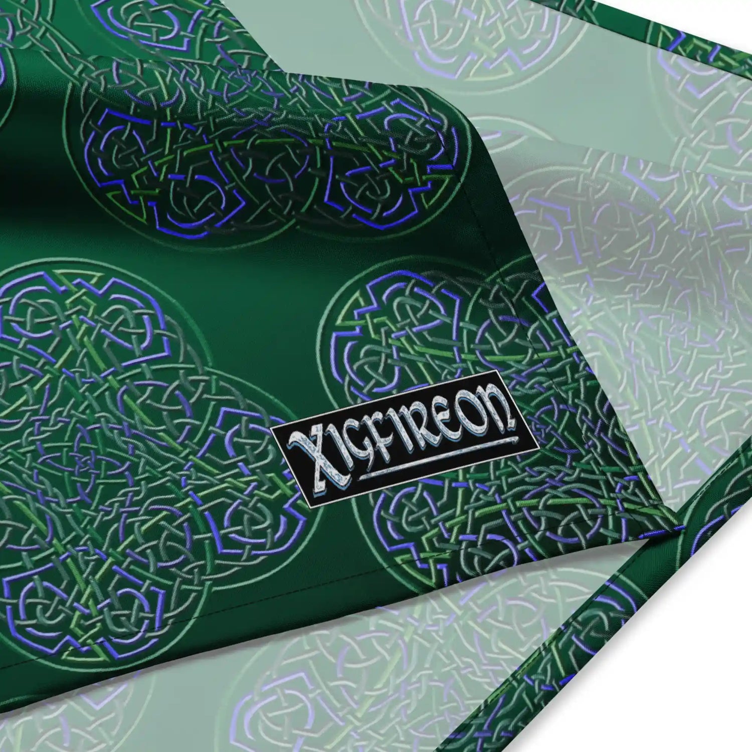 A close up view of the Xigfireon logo on a small sized (17.37 inch x 17.37 inch) `Reach Of The Spirit` Living Colour forest bandana.
