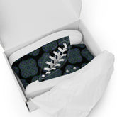 A shoebox containing a pair of Xigfireon black canvas high tops featuring the Living Colour iteration of the `Reach Of The Spirit` Celtic knot pattern.