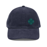 The front side of a navy blue Xigfireon vintage corduroy cap embroidered with the Living Colour iteration of the `Reach Of The Spirit` Celtic knot design offset to the left.
