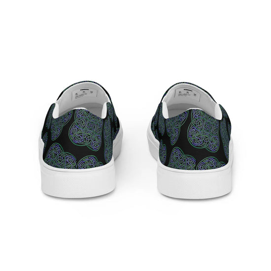 A view of the back of a pair of Xigfireon canvas slip-on shoes featuring the Living Colour on Black iteration of the `Reach Of The Spirit` Celtic knot pattern. The `Reach Of The Spirit` Celtic knot represents the Earth.