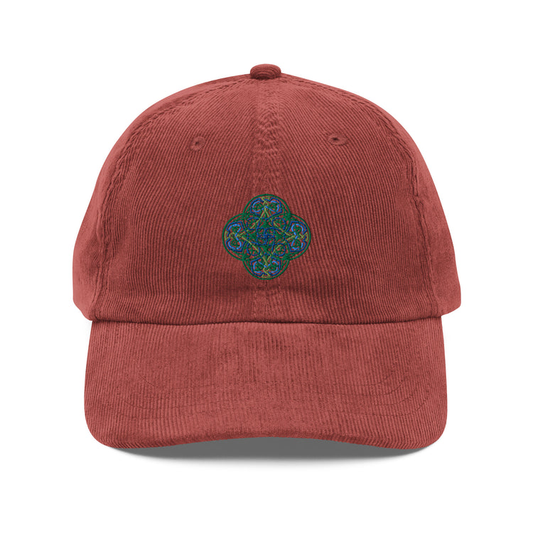 The front side of a burgundy Xigfireon vintage corduroy cap embroidered with the Living Colour iteration of the `Reach Of The Spirit` Celtic knot design.