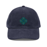 The front side of a navy blue Xigfireon vintage corduroy cap embroidered with the Living Colour iteration of the `Reach Of The Spirit` Celtic knot design.