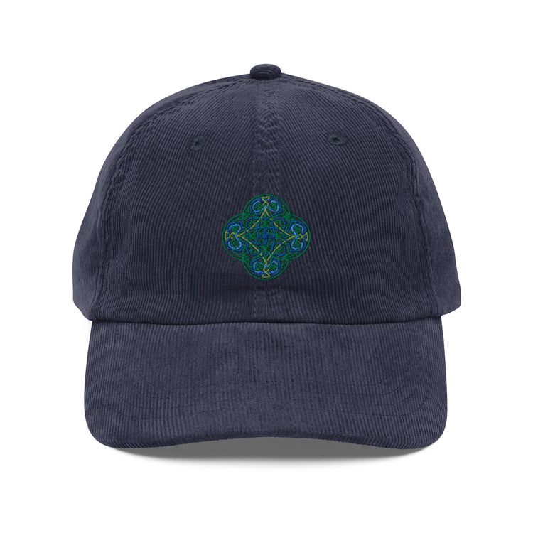 The front side of a navy blue Xigfireon vintage corduroy cap embroidered with the Living Colour iteration of the `Reach Of The Spirit` Celtic knot design.