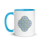 A Xigfireon white ceramic 11oz mug featuring the Living Colour iteration of the `Reach Of The Spirit` Celtic knot design, with blue handle and inside. This Celtic knot symbolizes Mother Earth.