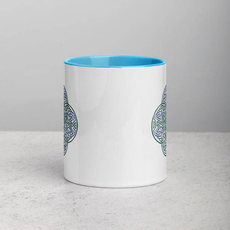 The front side of a Xigfireon white ceramic 11oz mug featuring the Living Colour iteration of the `Reach Of The Spirit` Celtic knot design, with blue handle and inside. This Celtic knot symbolizes Mother Earth.