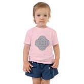 A young girl shown wearing a pink Xigfireon toddler graphic t-shirt featuring the Living Colour iteration of the `Reach Of The Spirit` Celtic knot design. The `Reach Of The Spirit` Celtic knot symbolizes the Earth.