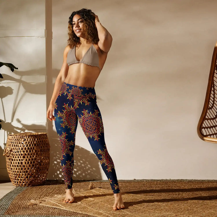 A woman in a studio wearing a pair of Xigfireon graphic yoga leggings featuring the Fire Colour Cosmos patterned series of the Morning Star Fire Celtic knot design.