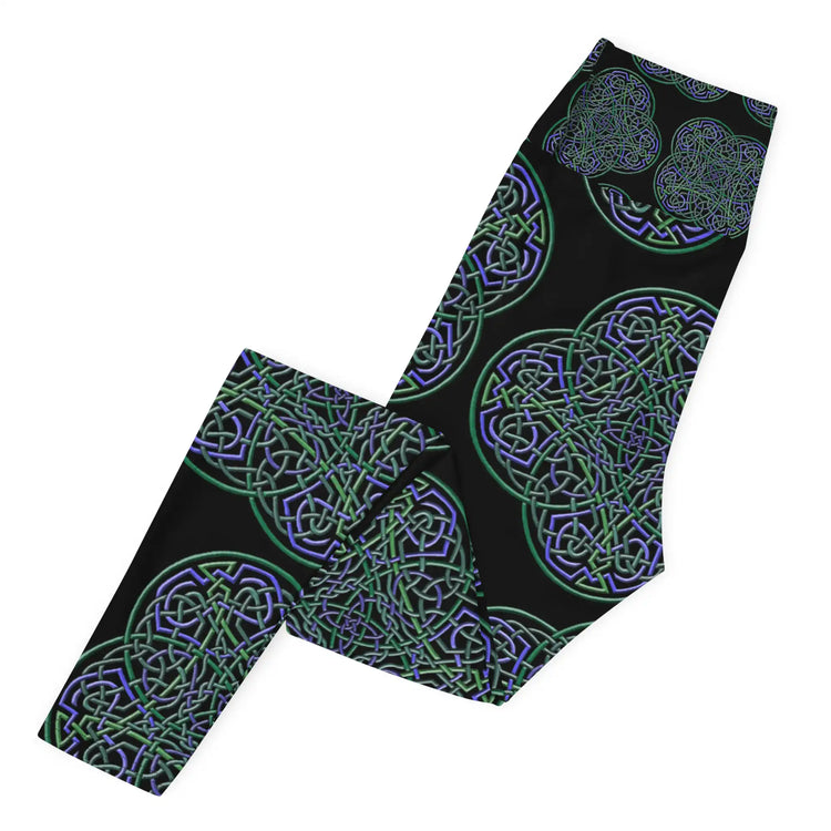 The left side of a folded pair of Xigfireon graphic yoga leggings featuring the Living Colour Black patterned series of the Reach Of The Spirit Celtic knot design.