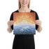 A young woman holding a 12 inch x 12 inch canvas print of the `Derivation II` Celtic knot design, which symbolizes the Sun and the Earth and their cosmic dance.