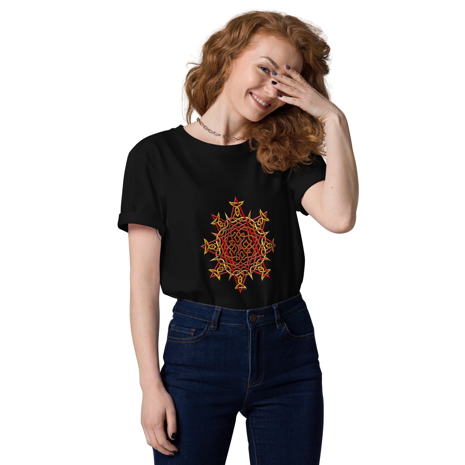 A young woman wearing a black Xigfireon graphic organic cotton t-shirt featuring the Fire Colour iteration of the `Morning Star Fire` Celtic knot design. The `Morning Star Fire` Celtic knot represents our benevolent Father Sun.