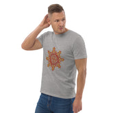 A young man wearing a heather grey Xigfireon graphic organic cotton t-shirt featuring the Fire Colour iteration of the `Morning Star Fire` Celtic knot design. The `Morning Star Fire` Celtic knot represents our benevolent Father Sun.