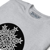 A close-up view of a sport grey Xigfireon graphic t-shirt featuring the Black & White Circle iteration of the `Morning Star Fire` Celtic knot design. The `Morning Star Fire` Celtic knot represents Father Sun and the eternal Cosmic Light.