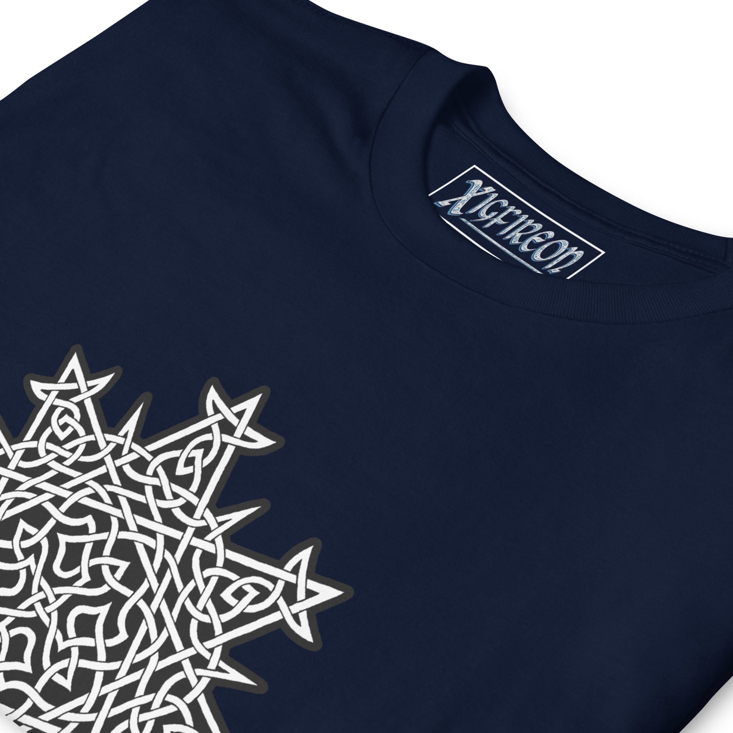 A close-up view of a navy blue Xigfireon graphic t-shirt featuring the Black & White Solid iteration of the `Morning Star Fire` Celtic knot design. The `Morning Star Fire` Celtic knot symbolizes the Sun.