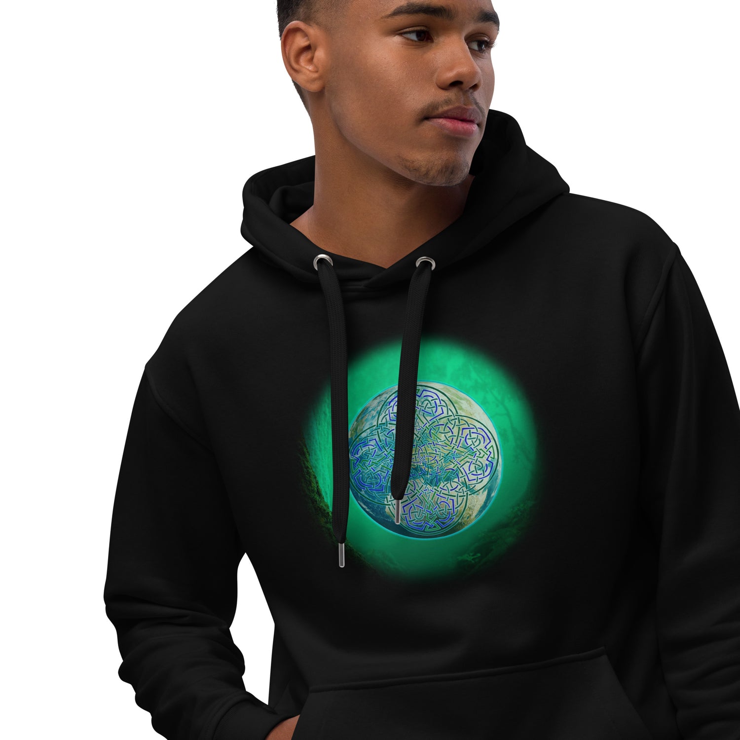 A young man wearing a black Xigfireon graphic eco-friendly hoodie featuring the Deep Forest iteration of the `Reach Of The Spirit` Celtic knot design. The `Reach Of The Spirit` Celtic knot symbolizes our beautiful Mother Earth.