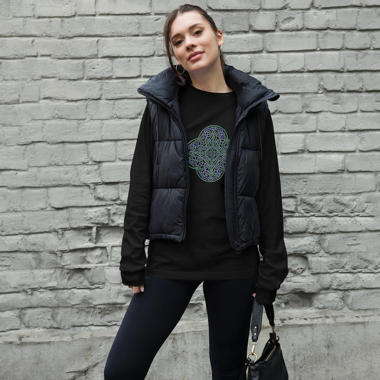 A young woman wearing a black Xigfireon long sleeve graphic t-shirt featuring the Living Colour iteration of the `Reach Of The Spirit` Celtic knot design. The `Reach Of The Spirit` Celtic knot symbolizes Mother Earth.